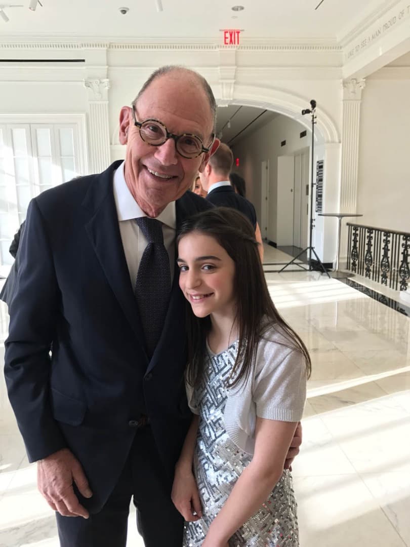 Man in round glasses with a girl in a sequined dress
