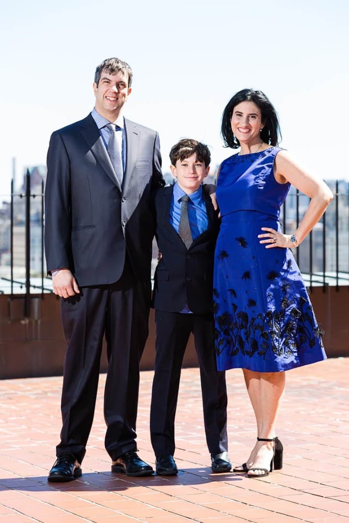 Mother, father and son standing on a rooftop terrace