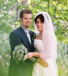 Bride and groom embracing outdoors, the groom holding her bouquet
